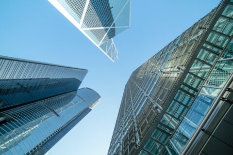 Low-angle photo of commercial buildings under the blue sky.