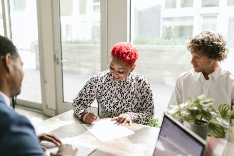 Man and woman talk with bank officers about types of financing.