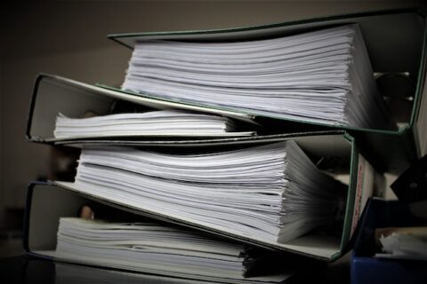 Photo of a pile of papers, documents, and files about commercial property history.