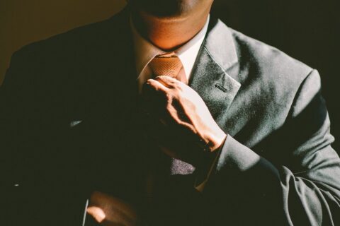 Man in business suit adjusting tie.